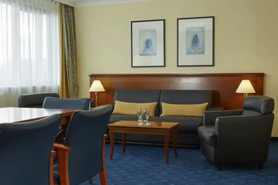 Wohnbereich der Grandsuite mit einer Sitzgruppe. Über der Couch hängen zwei Bilder.