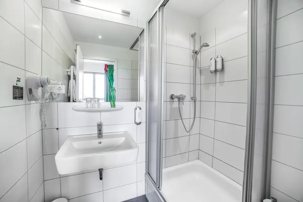 Dusche neben dem Waschbecken im Bad. 