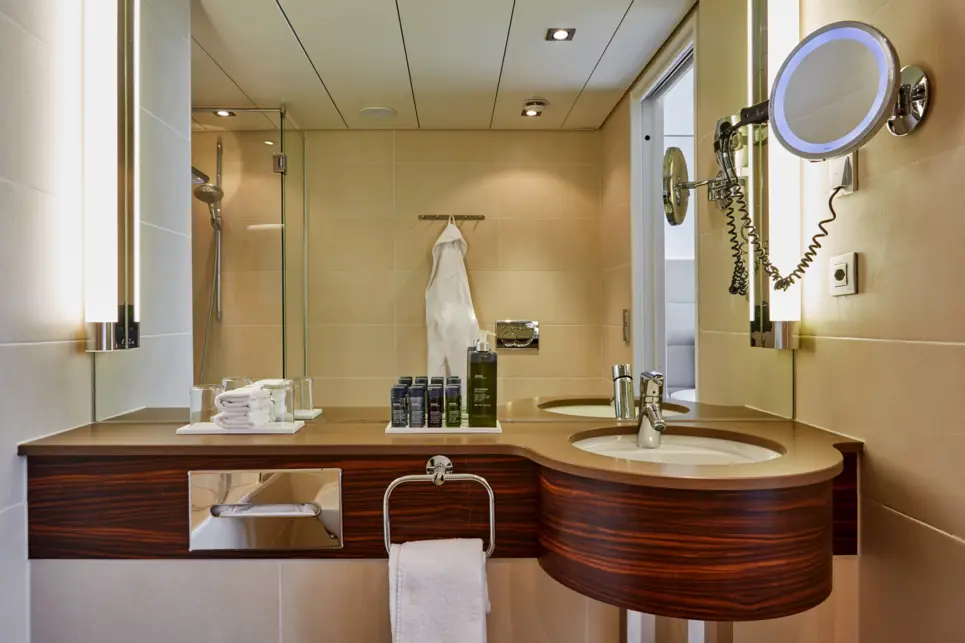 Badezimemr mit einem holzernen Waschbecken. Über dem Waschbecken hängt ein großer Spiegel.