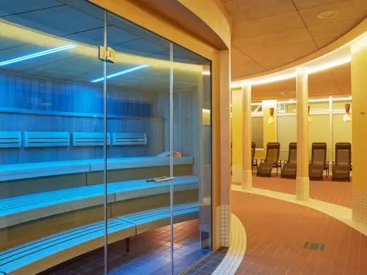 Saunalandschaft mit einer blau beleuchteten Saunakabine.