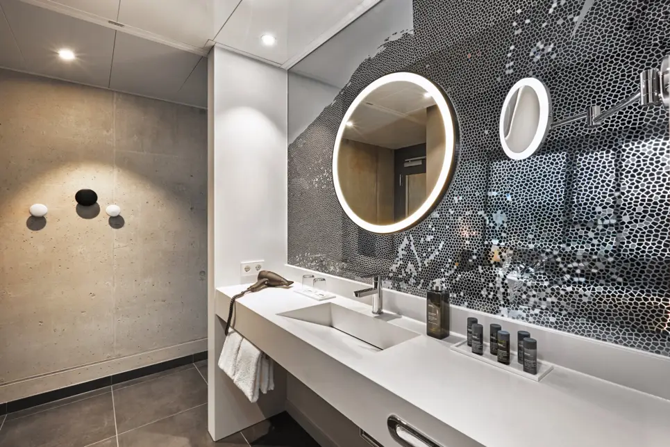 Waschnische mit einem runden Spiegel.