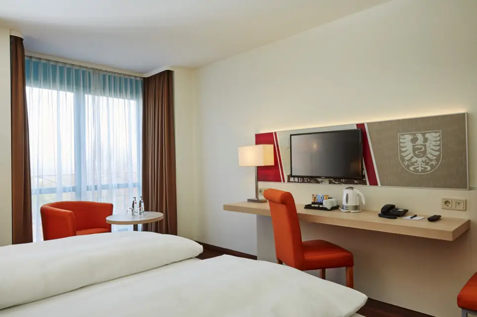 Schreibtisch und kleine Sitzecke im Hotelzimmer.