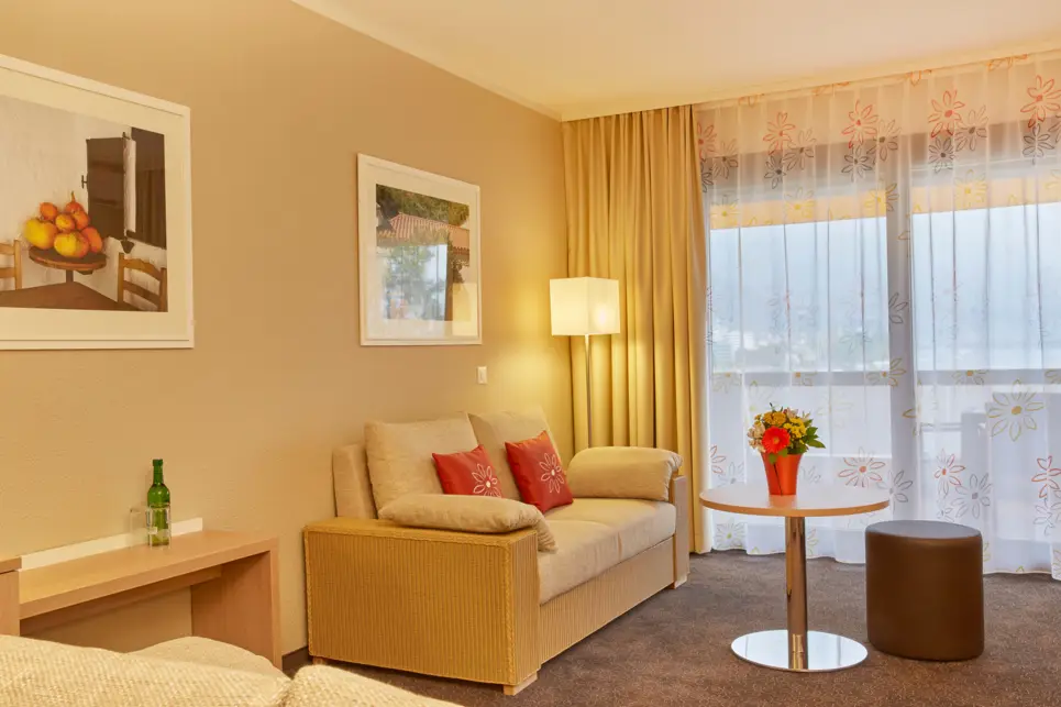 Hotelzimmer mit einer Sitzecke mit einer Couch und einem Sessel.