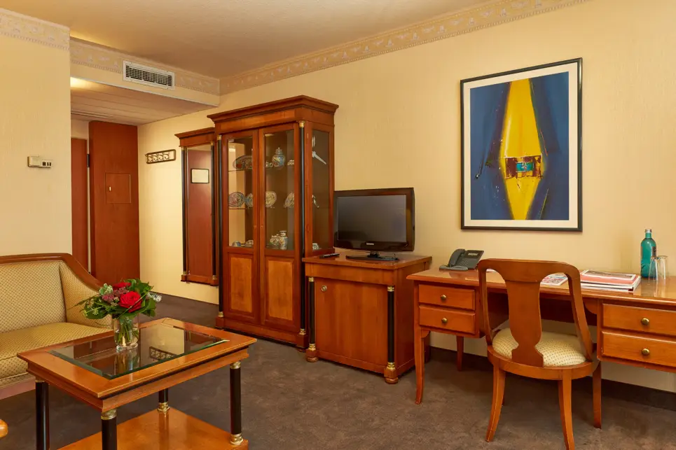 Wohnbereich der Suite mit Schränken, einem Schreibtisch und einer Sitzecke.