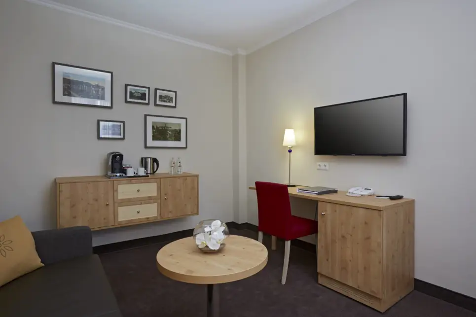 Wohnbereich mit einer Couch, einer Kommode und einem Schreibtisch.