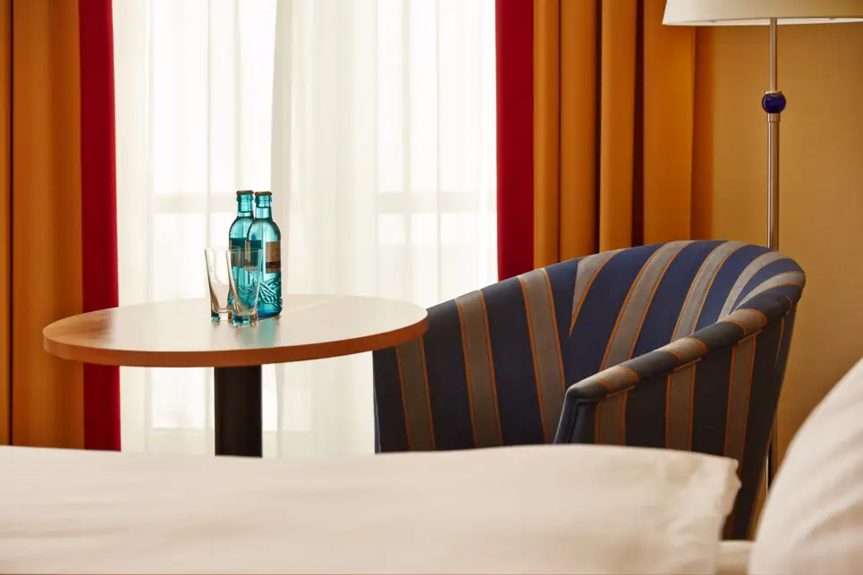 Detailaufnahme voneinem Sessel mit einem Tisch neben dem Bett.