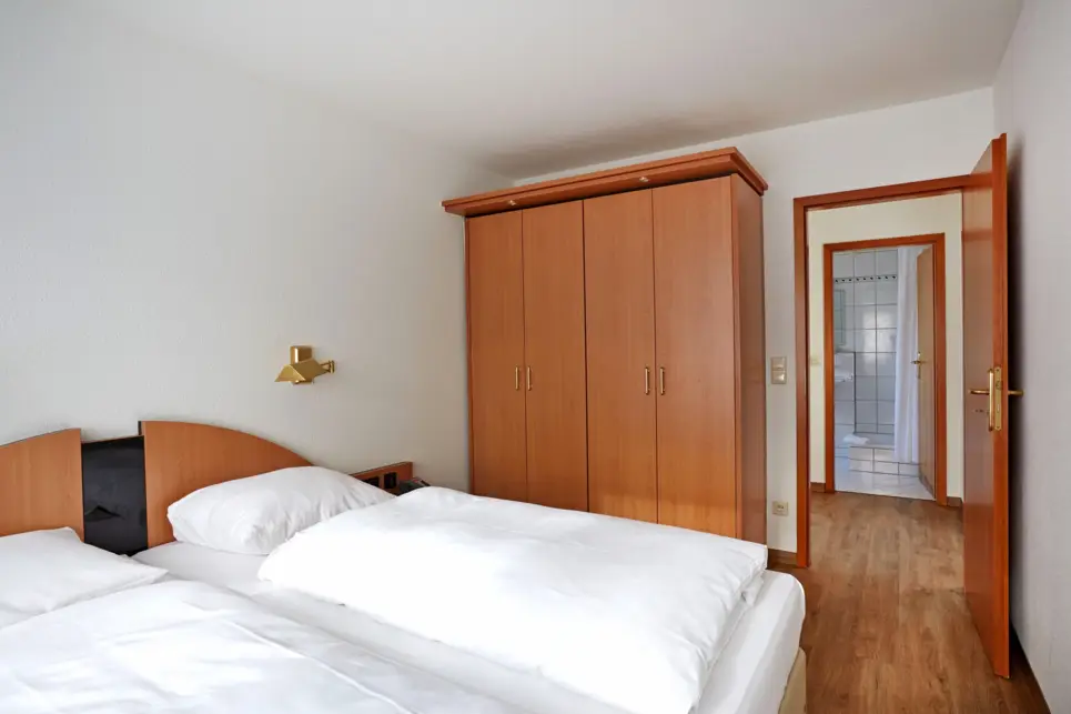 Schlafbereich mit einem Doppelbett und einem Kleiderschrank.