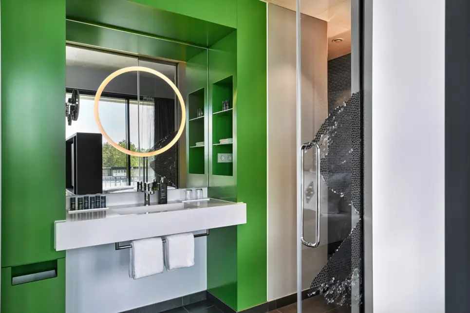 Waschbecken mit einem runden Spiegel in einer Nische.