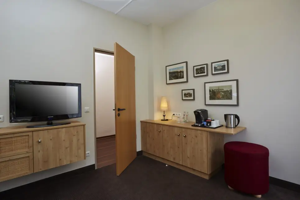 Wohnbereich mit zwei Kommoden und einem Fernseher.