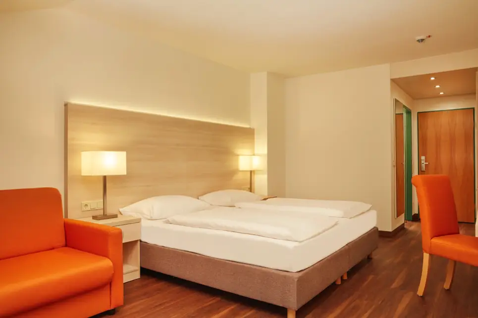 Doppelbett mit zwei großen Nachttischlampen.