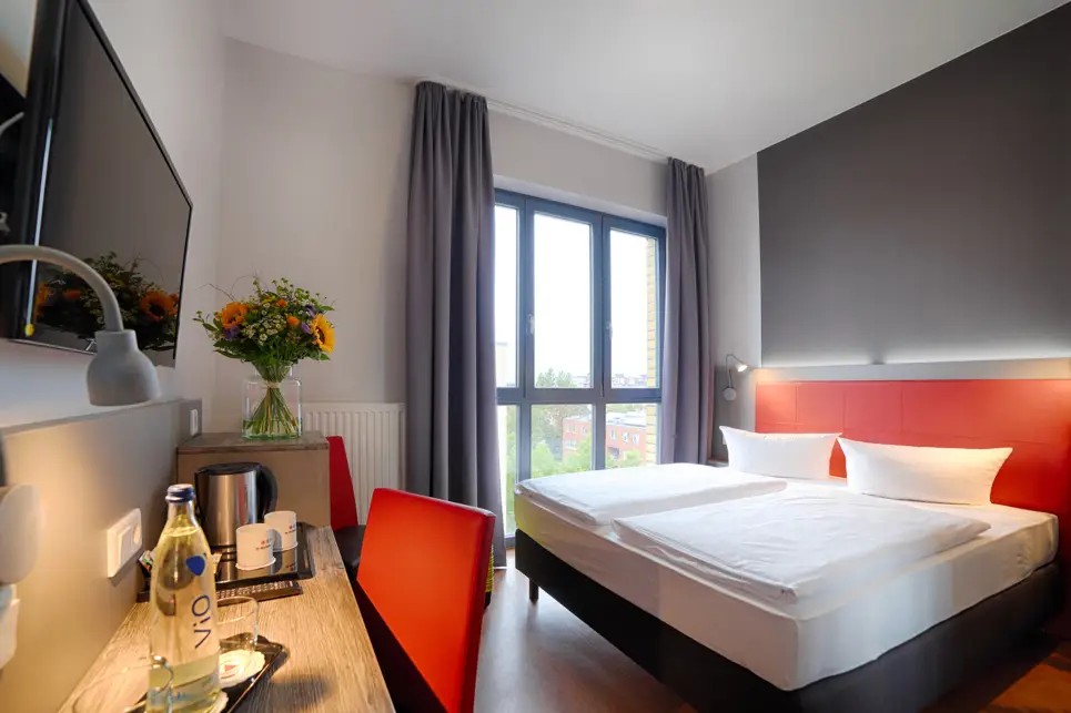 Detailaufnahme vom Doppelbett mit einer bunten Rückwand.