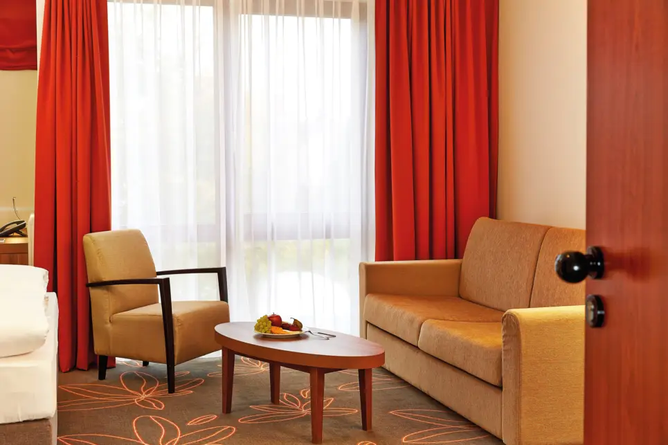 Sitzecke im Hotelzimmer mit einer Couch und einem Sessel.