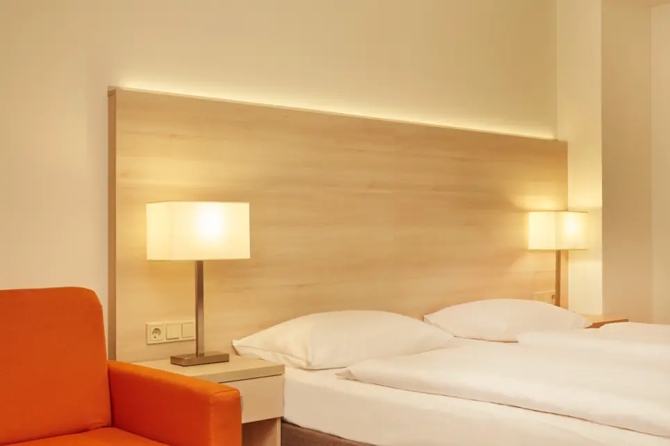 Doppelbett mit zwei großen Nachttischlampen.