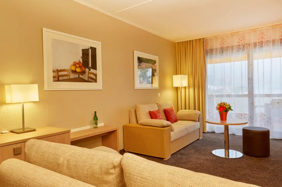 Hotelzimmer mit einer Sitzecke mit einer Couch und einem Sessel.