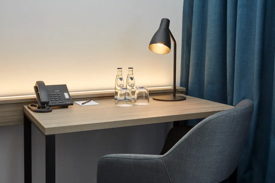 Nahaufnahme vom Schreibtisch mit einem Sessel und einem Telefon.