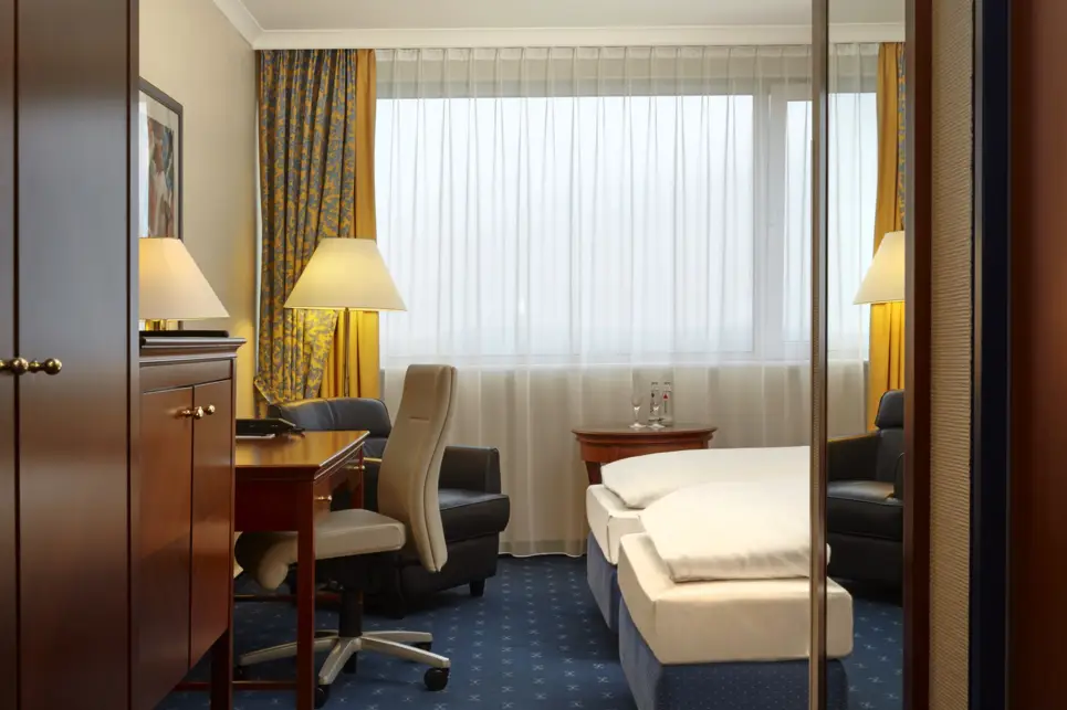 Blick in ein Komfortzimmer mit einem Schreibtisch und einem Sessel.