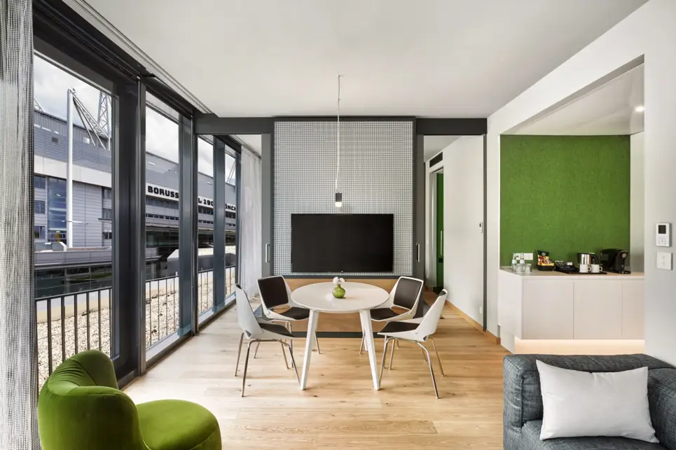 Sitzbereich mit vier Stühlen und einem Fernseher.