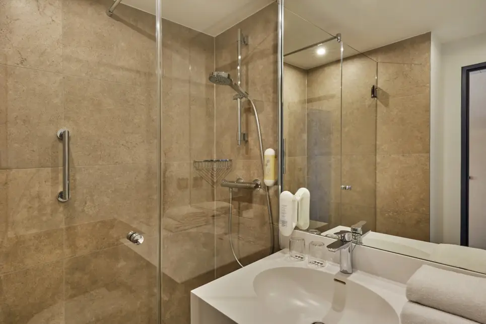 Große Dusche und ein Waschbecken im Badezimmer.