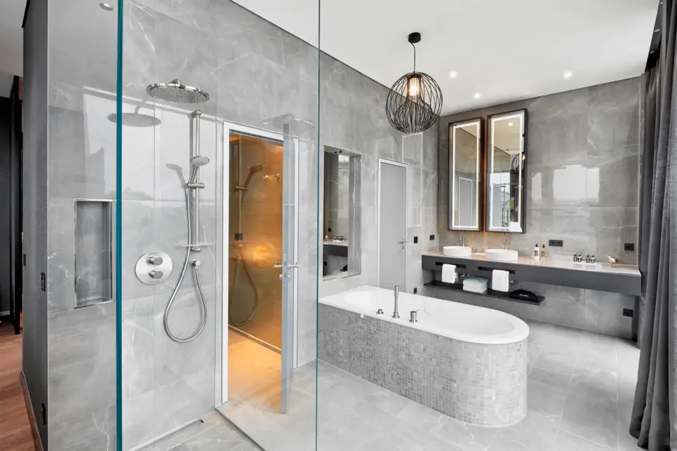 Badezimmer mit einer Glasdusche und einer freistehenden Badewanne.